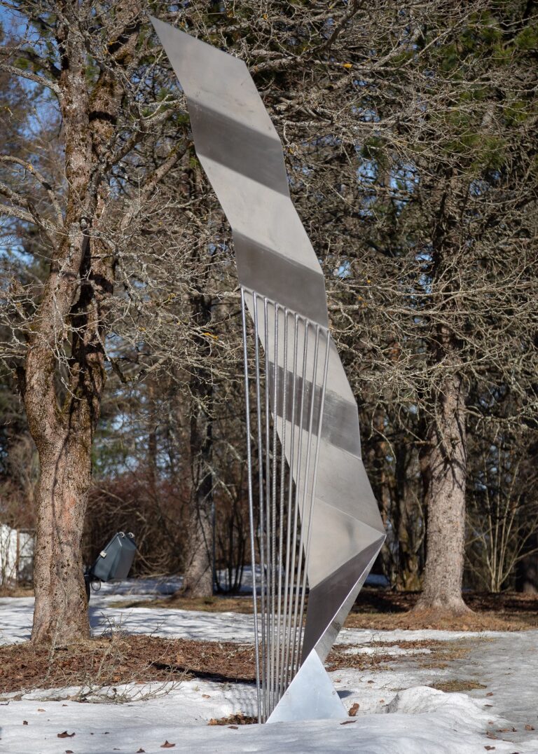 Steel sculpture bent into a wave-like shape.