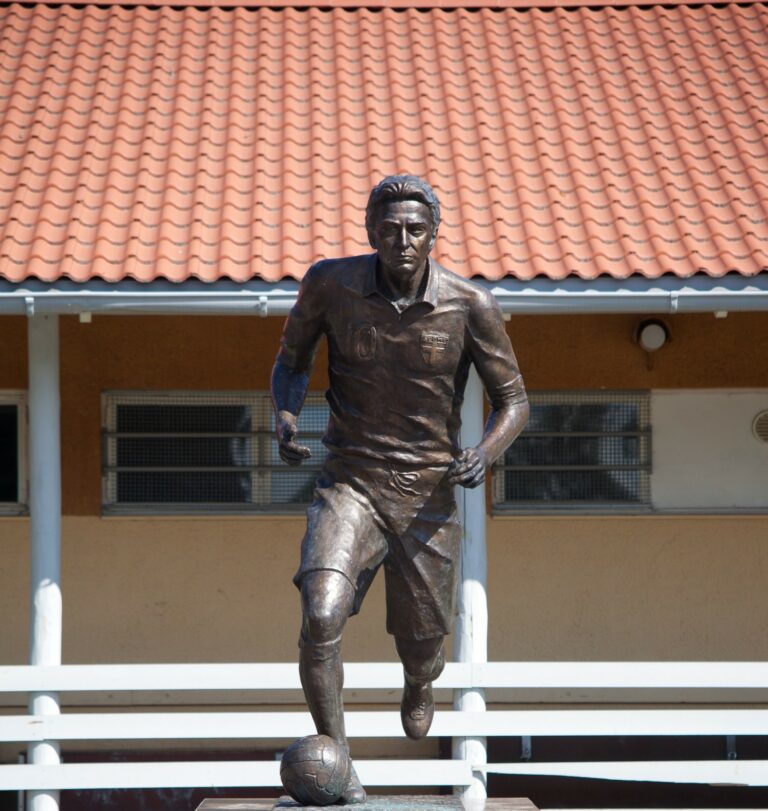 Bronze sculpture depicting a football player.