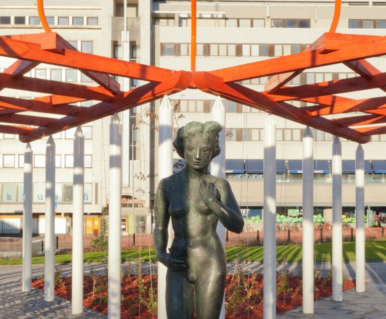 A bronze sculpture depicting a nude woman holding a lingonberry branch.