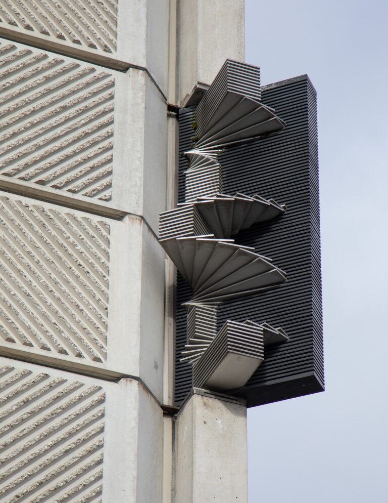 A metallic, abstract fan-like sculpture attached to the facade of the building.