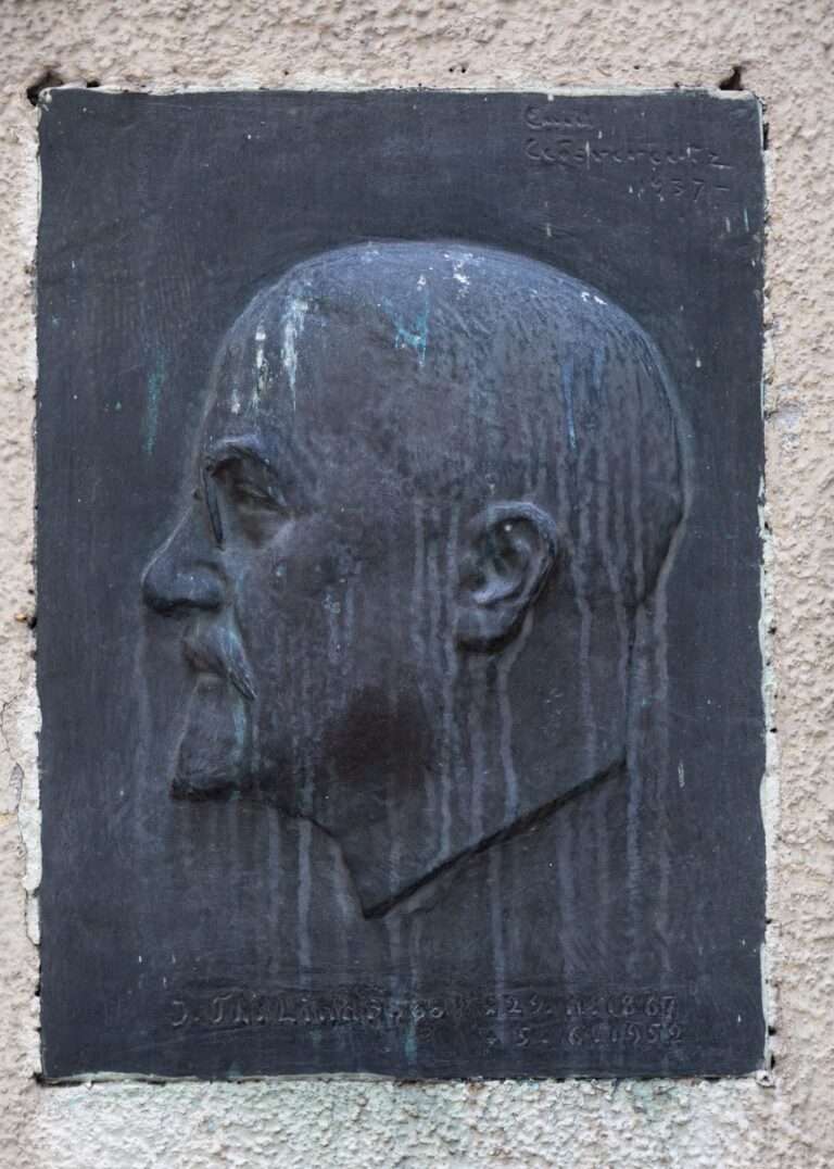 Bronze relief with a side profile of a man.