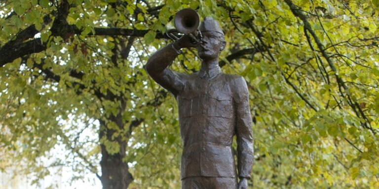 Statue of a soldier boy blowing into a cornet.