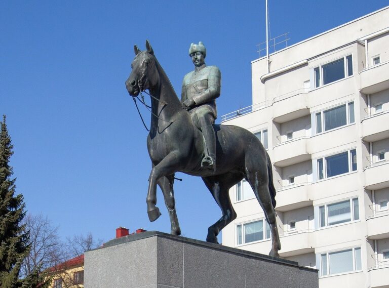 A bronze statue depicting a man in a military uniform riding a horse.