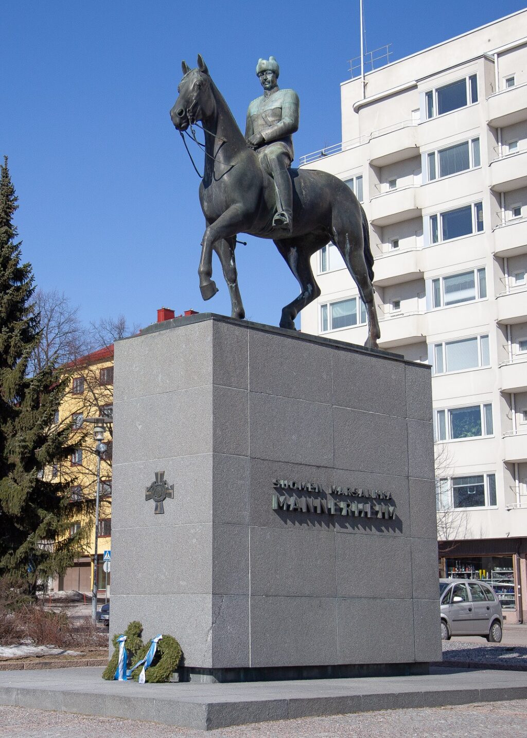 A bronze statue depicting a man in a military uniform riding a horse.