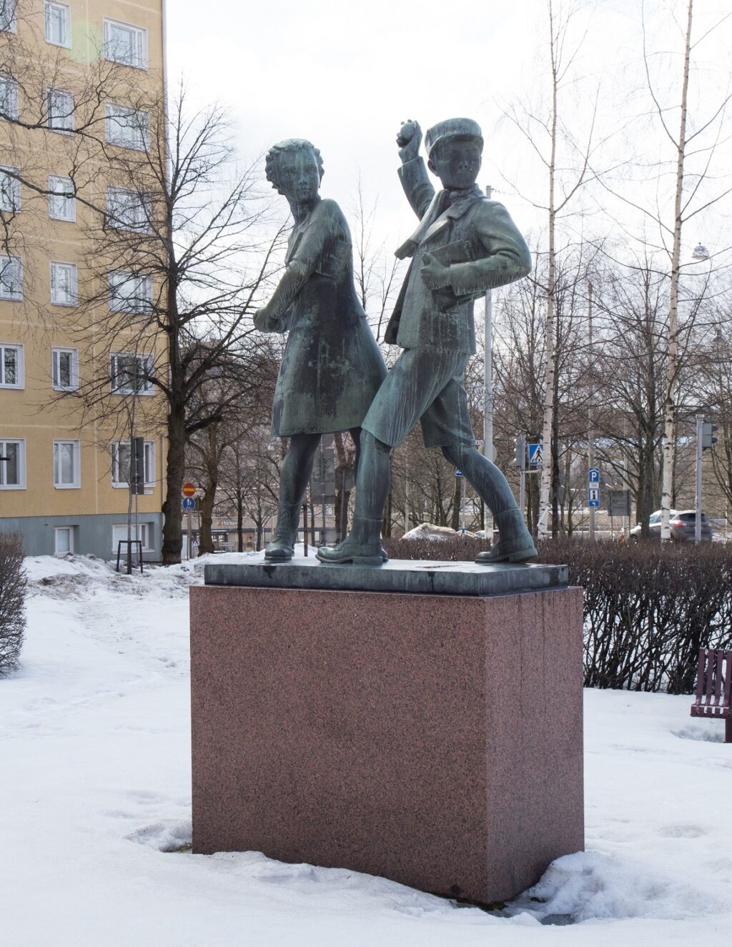 A bronze sculpture depicting a girl and a boy playing a snowball fight.