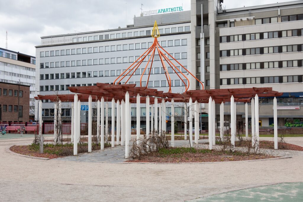 A square with a five-winged, geometric pergola installation.