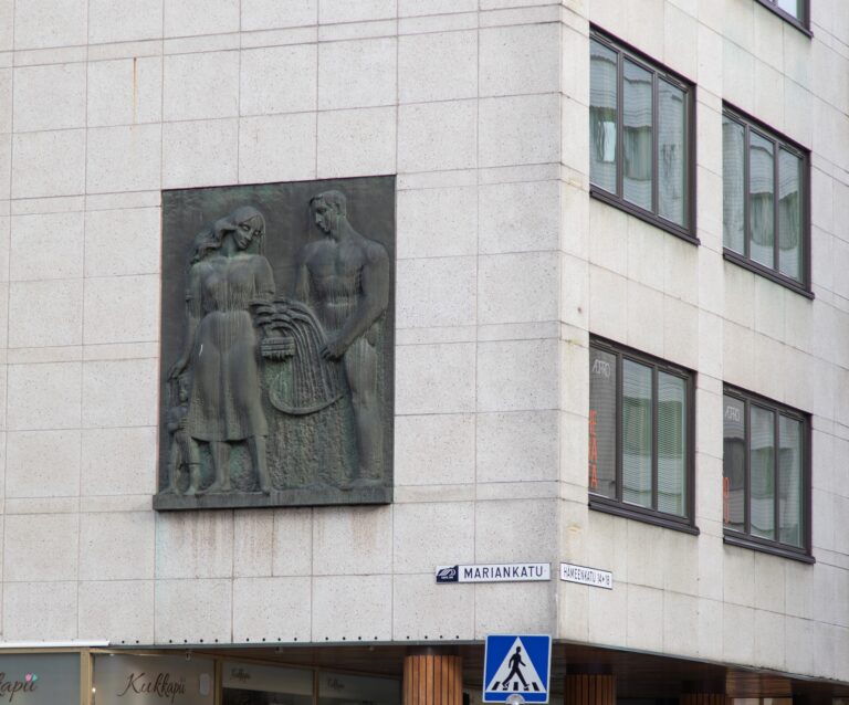 A bronze relief depicting a family gathering a grain harvest.