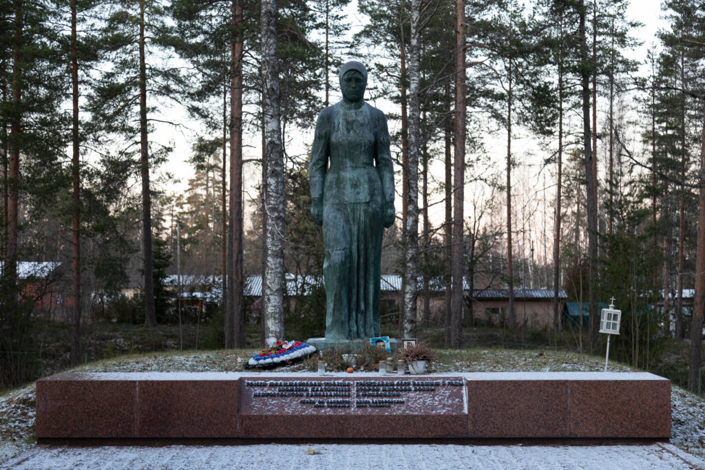 A bronze statue depicting a female figure standing with a serious expression.