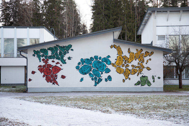 A mural painted on the wall of the building depicting a world map made of fingerprints. The different continents are painted with different colors and Europe is missing from the map.