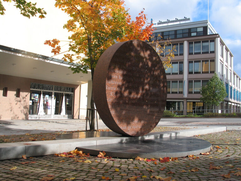 Round red granite sculpture with engraved text.