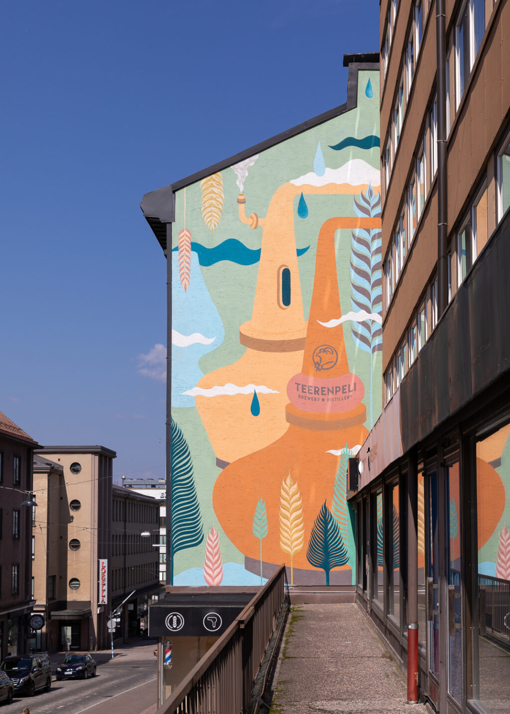 Street view of the side of a house with a colorful mural painted on it.